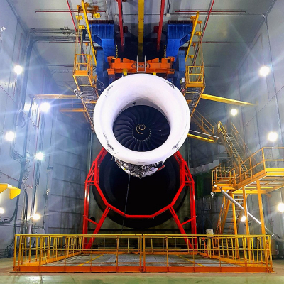 Researchers developed a technique called chemical species tomography that can capture carbon dioxide exhaust from a commercial airplane engine. To image such a large area, the researchers used a 7-m diameter optical mounting frame (red) located just 3 m from the exit nozzle of the engine. The testing facility is at the Instituto Nacional de Tecnica Aeroespacial (INTA) in Madrid. Credit: Gordon Humphries, University of Strathclyde Photo of jet engine being tested